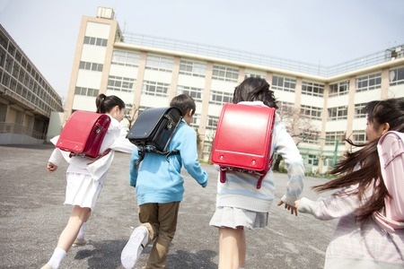 49293267 - rear view of four elementary school students to school